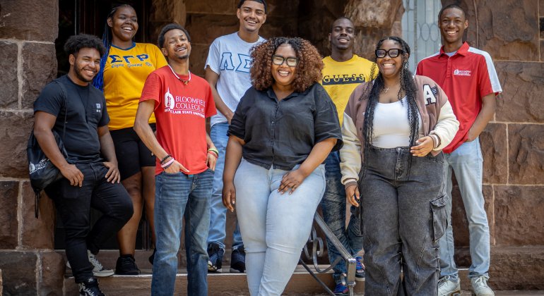 Students smiling on steps of a building
