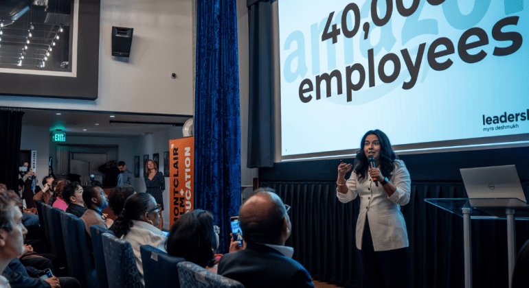 Woman entrepreneur presenting in front of a large audience