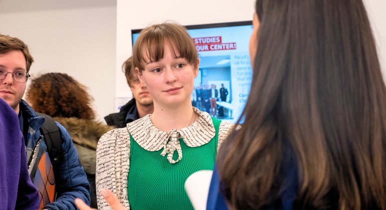 Students speaking to recruiter at a career fair event.