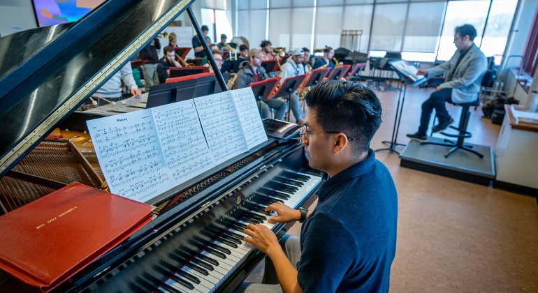 jazz pianist rehearsing with jazz ensemble in Cali classroom