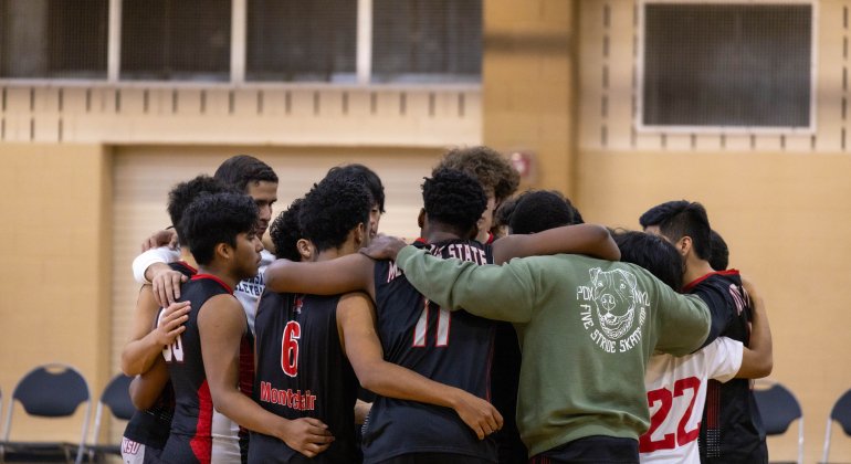 men's club volleyball in a huddle