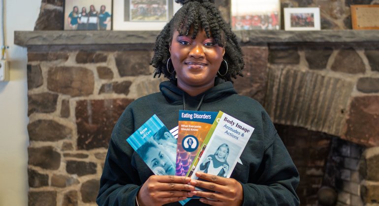 a peer health advocate holding up several pamphlets
