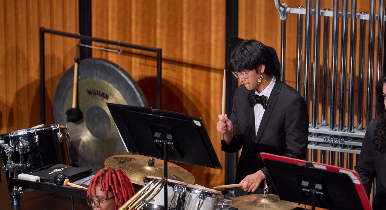 Percussion student performing on stage with drum