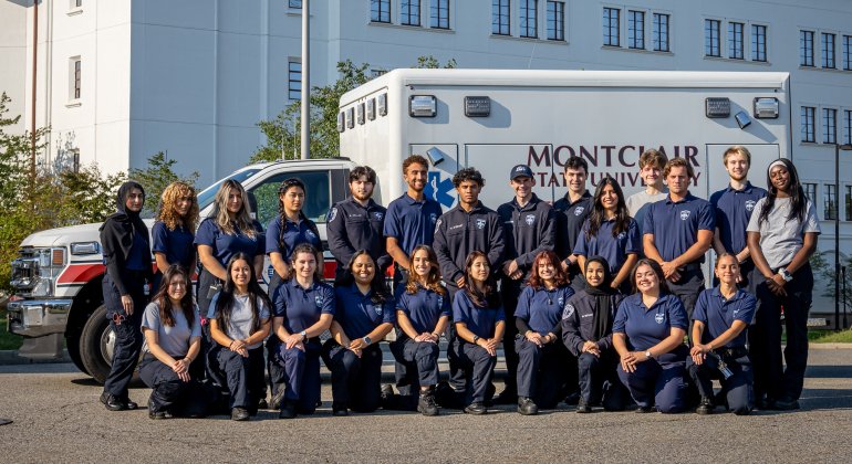 Montclair State University Emergency Medical Services team members pose in front of an ambulance on campus.