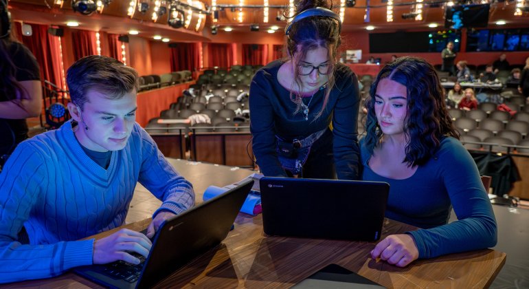 students on stage with laptops