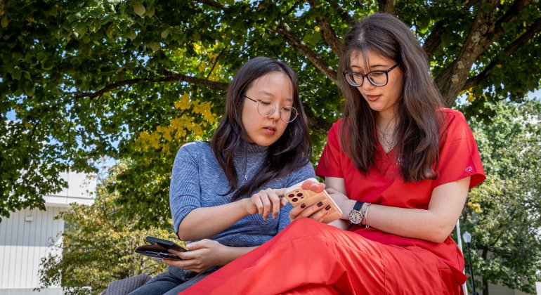 two students looking at phone