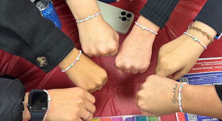 Students participating in a beading event