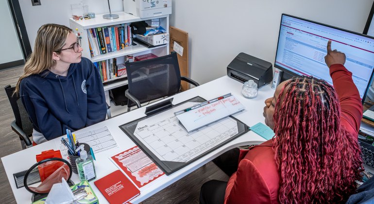 a student advising appointment where the advisor is showing the student something on a computer screen