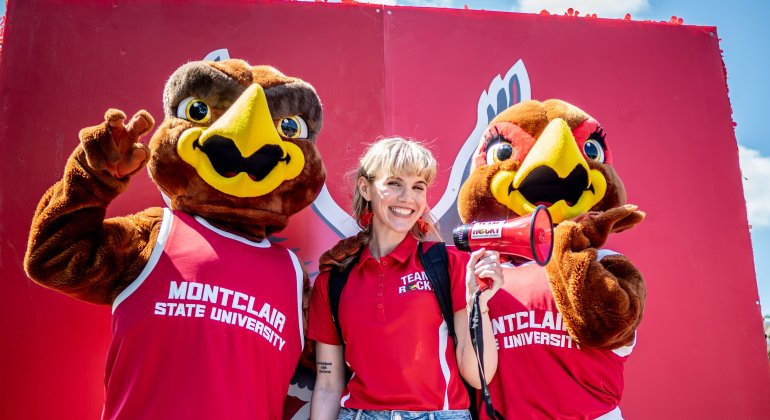 Student poses with Rocky and Roxy at orientation.