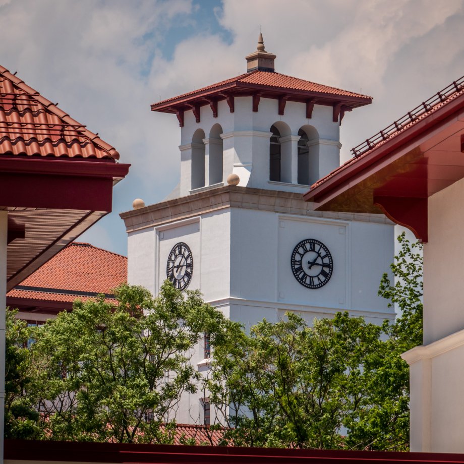 University Hall clocktower between other buildings on campus