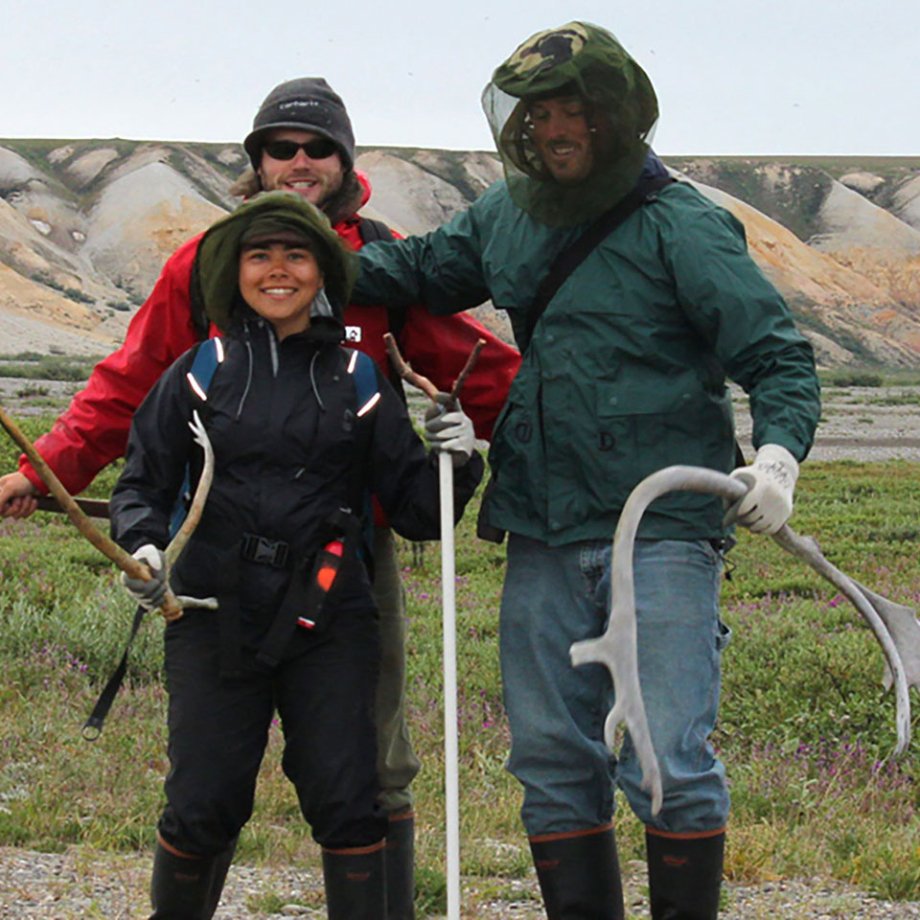 students in field posing with equipment