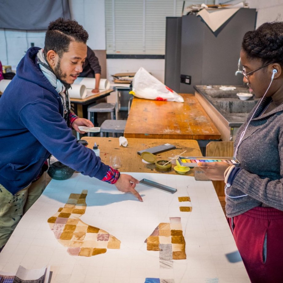 Two students in a drawing class working together