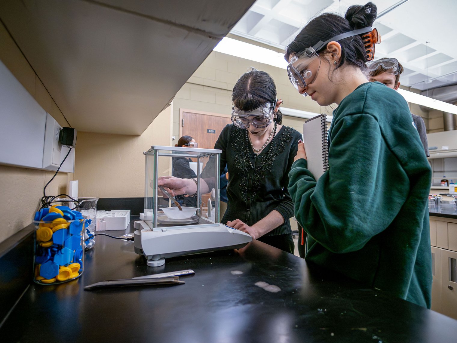 Katie Cicero looks on as Sarah Bowers lifts a test tube in the Chemistry lab.
