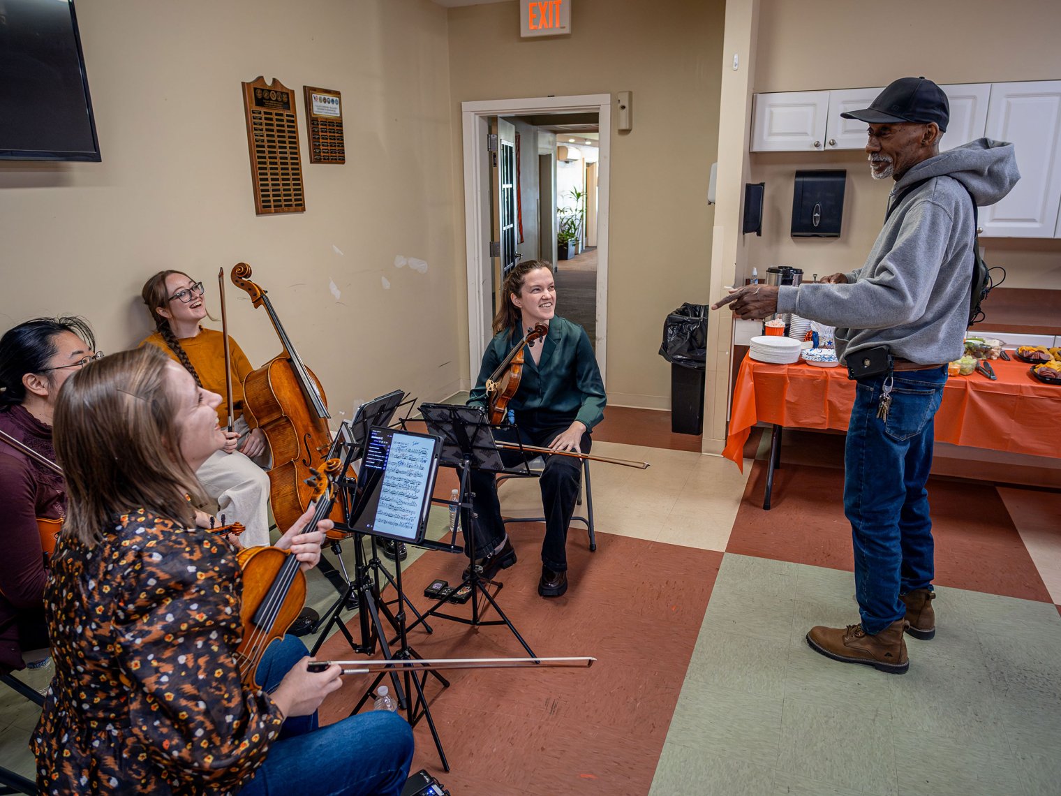 : A retired veteran stands and chats with members of the Trillium String Quartet.