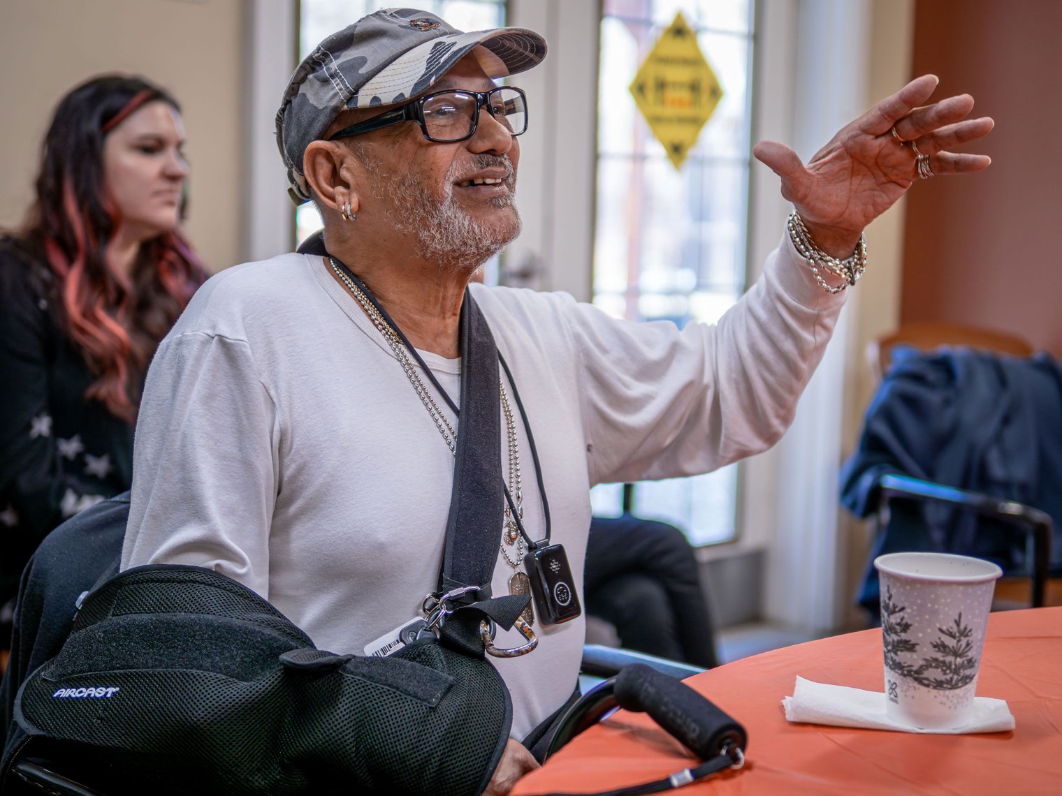 A veteran motions with his hand as he listens to a musical performance.