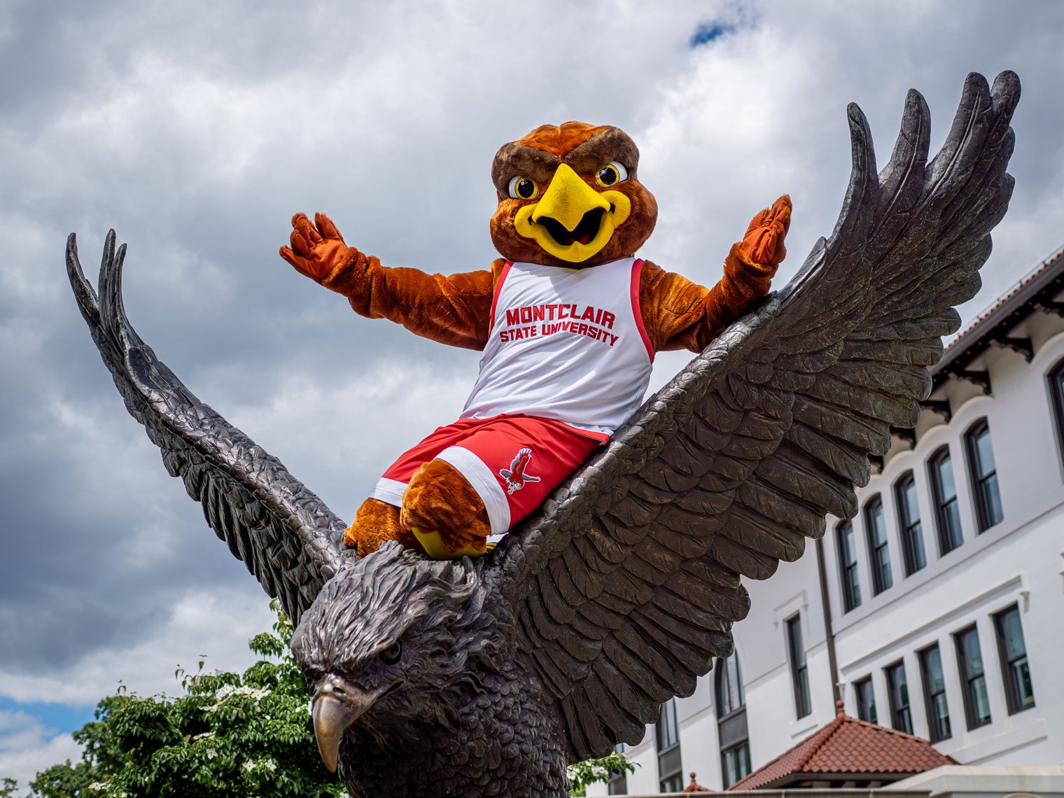 Rocky the Red Hawk sits atop a bronze Red Hawk statue.