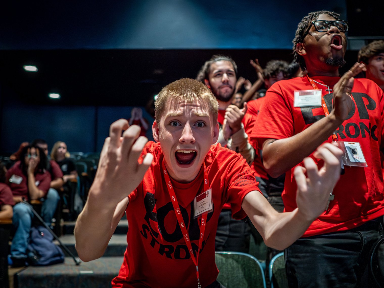 A student in a red shirt gestures excitedly.