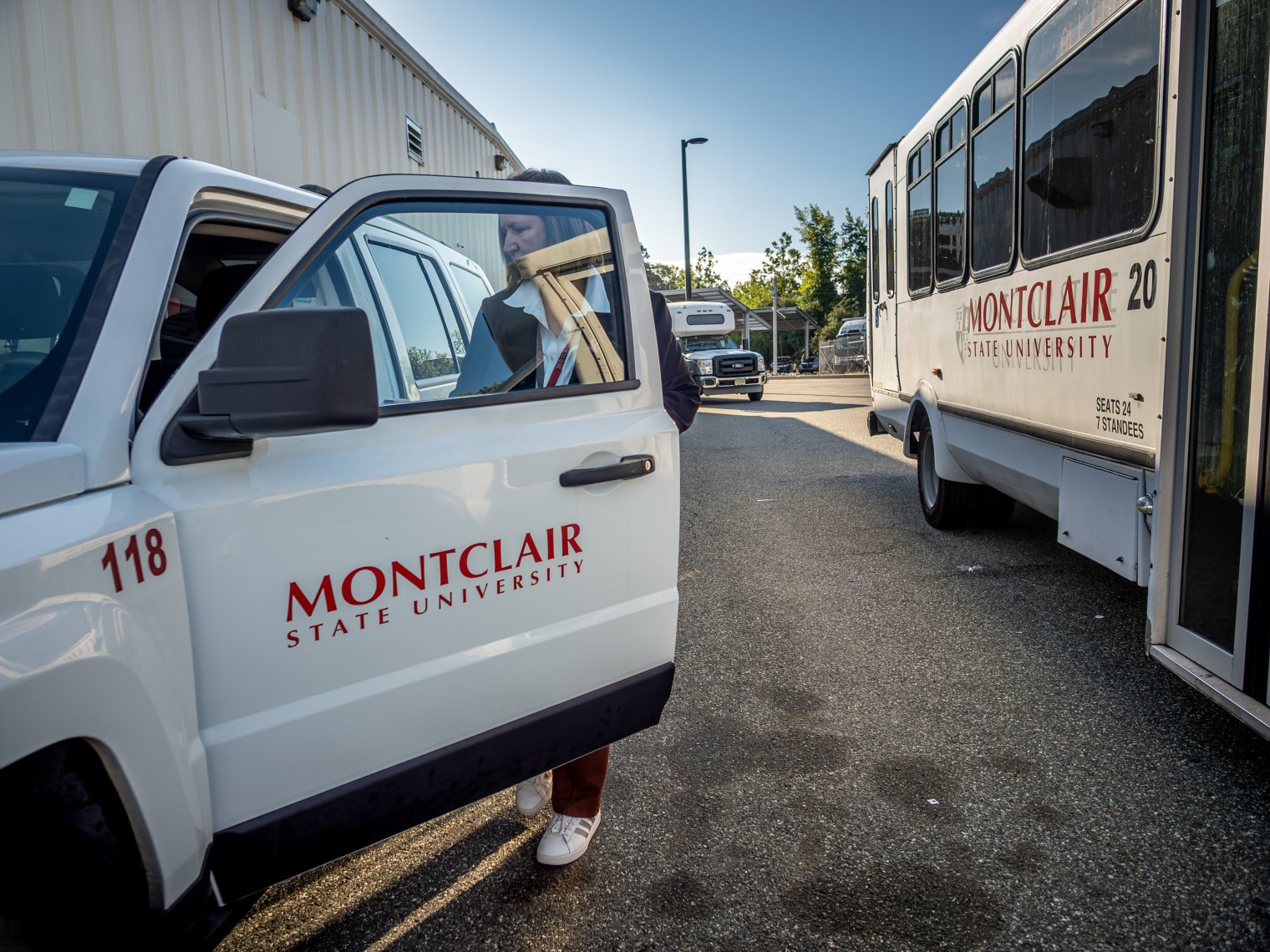 Monica opening the car door with Montclair State University on the car door.