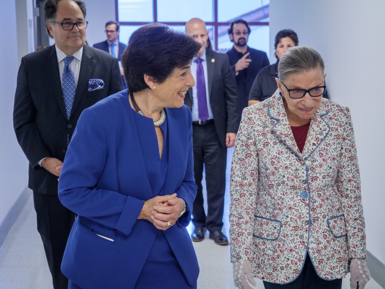 Ruth and Susan walking through a hall together.
