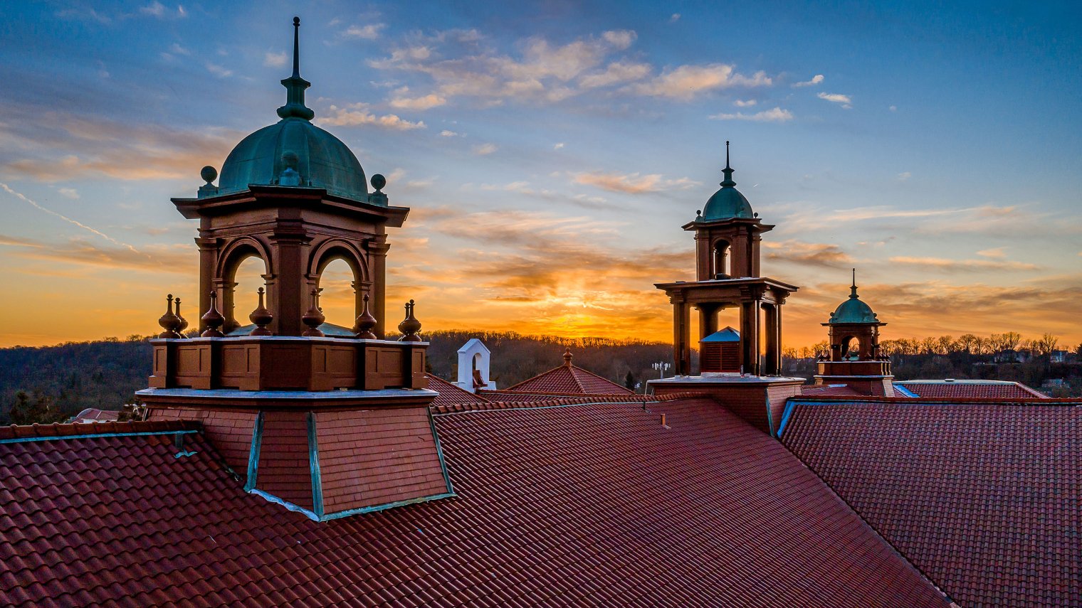 view of college hall belltower with the sun setting behind it