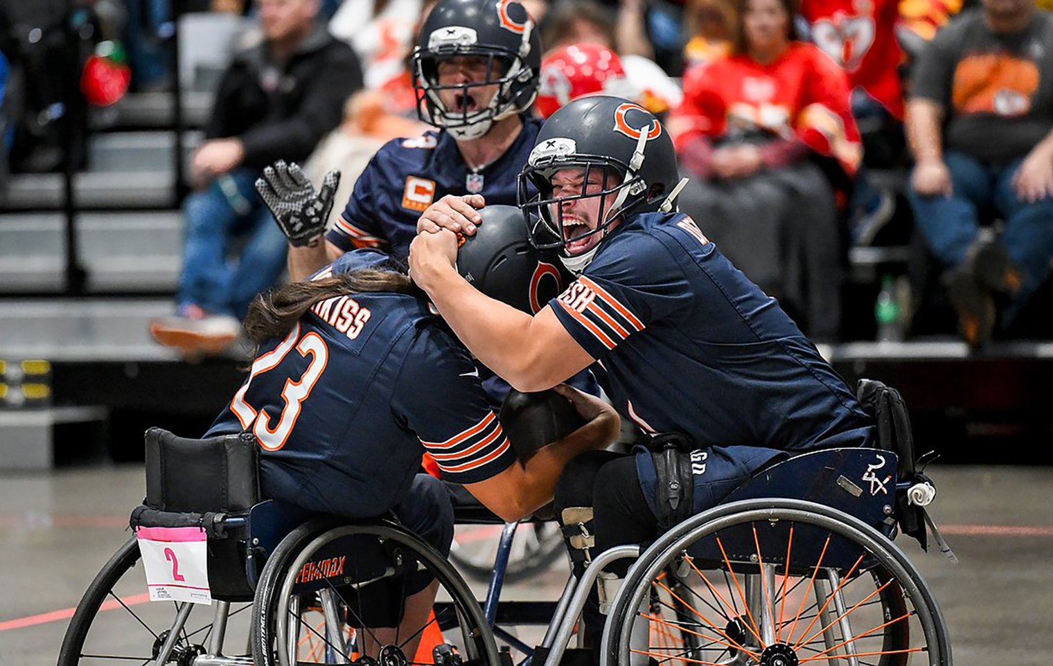 A wheelchair football player tackles another on a court.