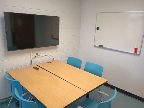 a desk with 5 chairs and monitor