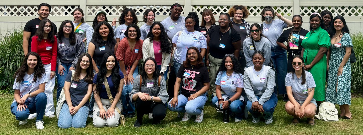 A large group of 29 Montclair State University AmeriCorps members pose together, smiling for a group photo. 