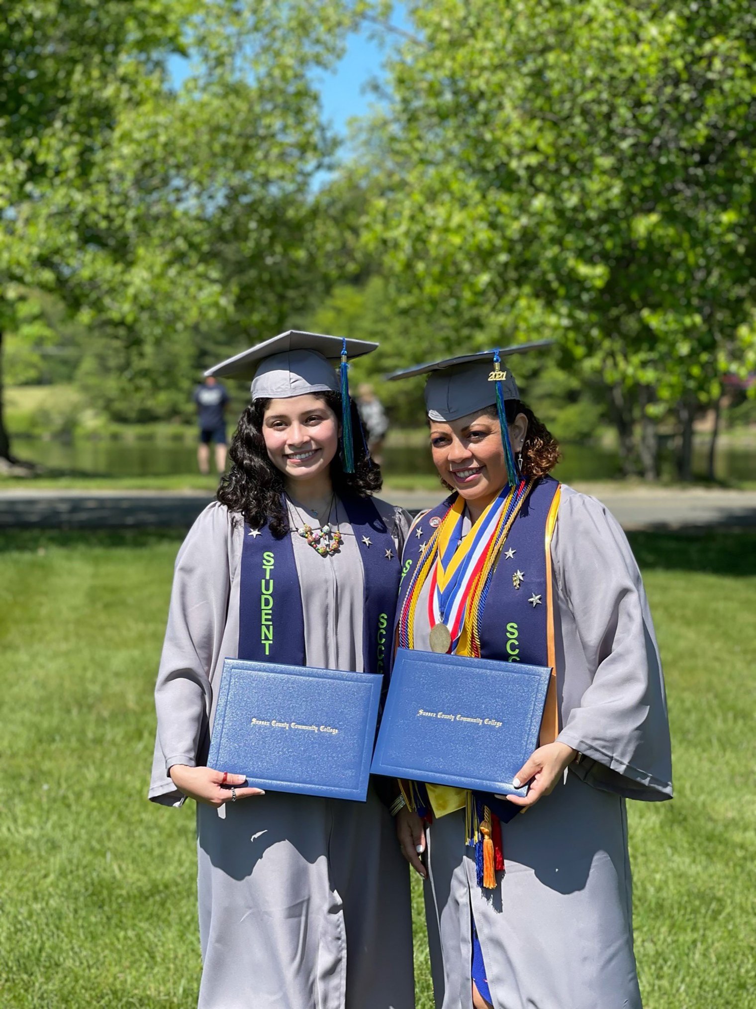 Angel Bernales and her mother Illiana Woodhull hold diplomas. 
