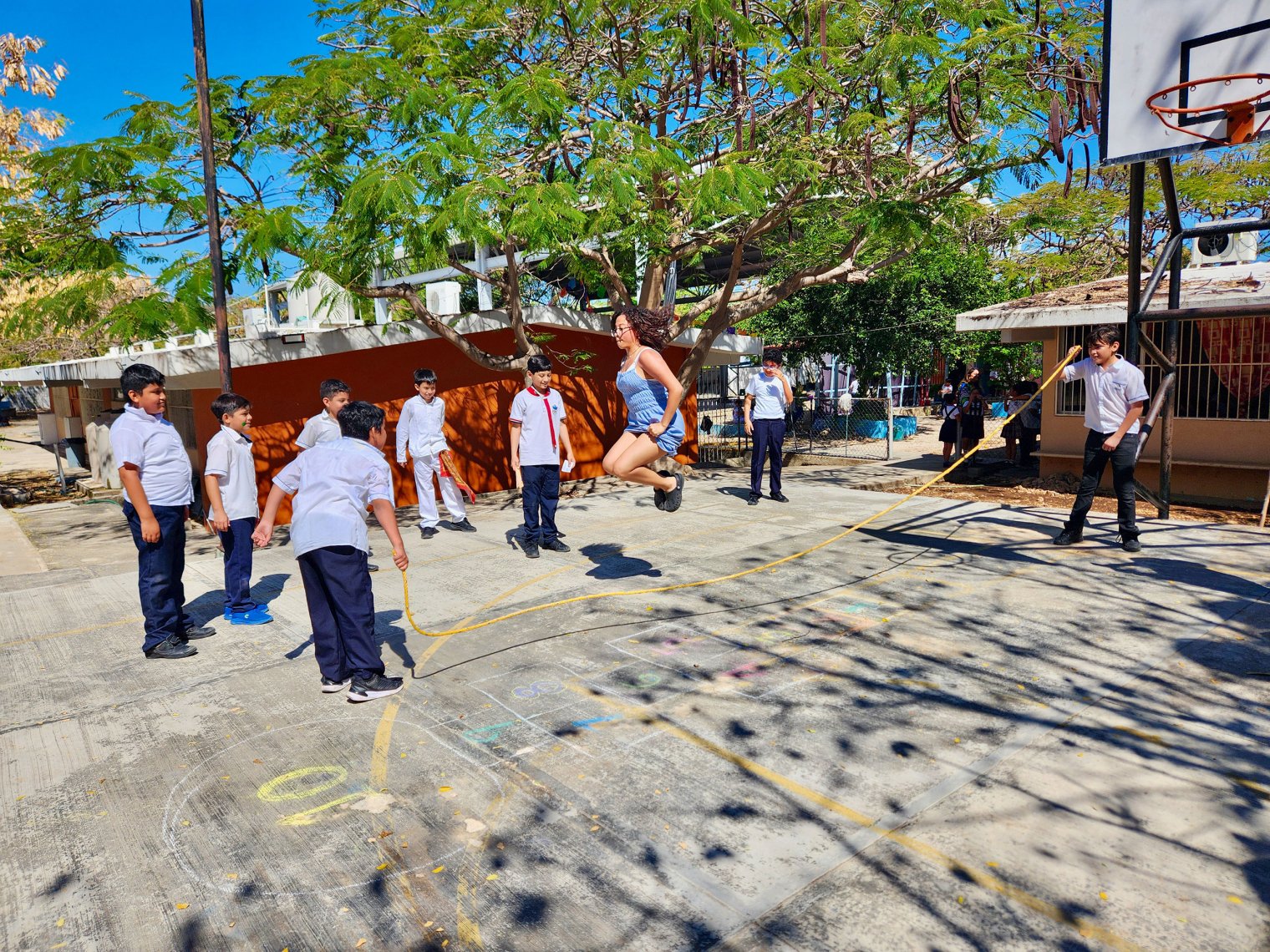 A Montclair student jumps rope in Mérida surrounded by group of children.