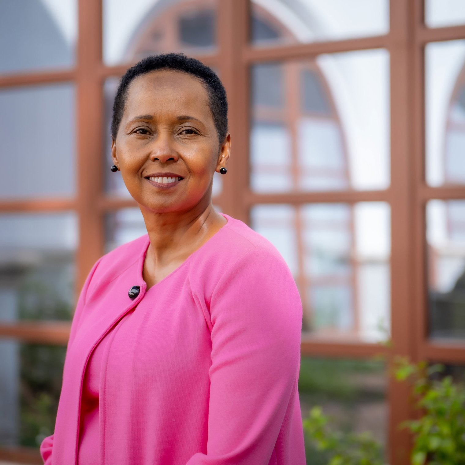 Wamwari Waichungo posing smiling while wearing a pink jacket