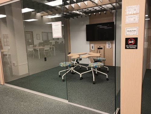 a glass window study pod with individual desks and monitor 