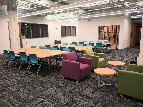 a study lounge with multiple desks and chairs