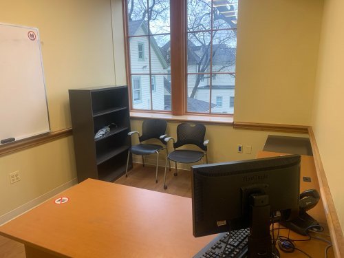 study room with table, chairs bookshelf, computer, and whiteboard