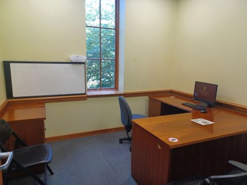 study room with table, chairs, computer, and whiteboard