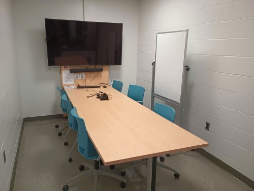 study space with conference table, monitor, and whiteboard