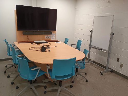 study space with conference table, monitor, and whiteboard