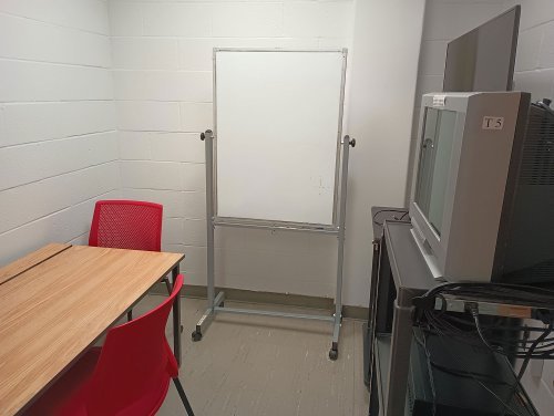 Viewing room with desk, chairs, monitor, dvd player, and a whiteboard