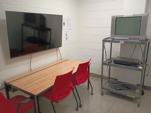 Viewing room with desk, chairs, 2 monitors, and a dvd player
