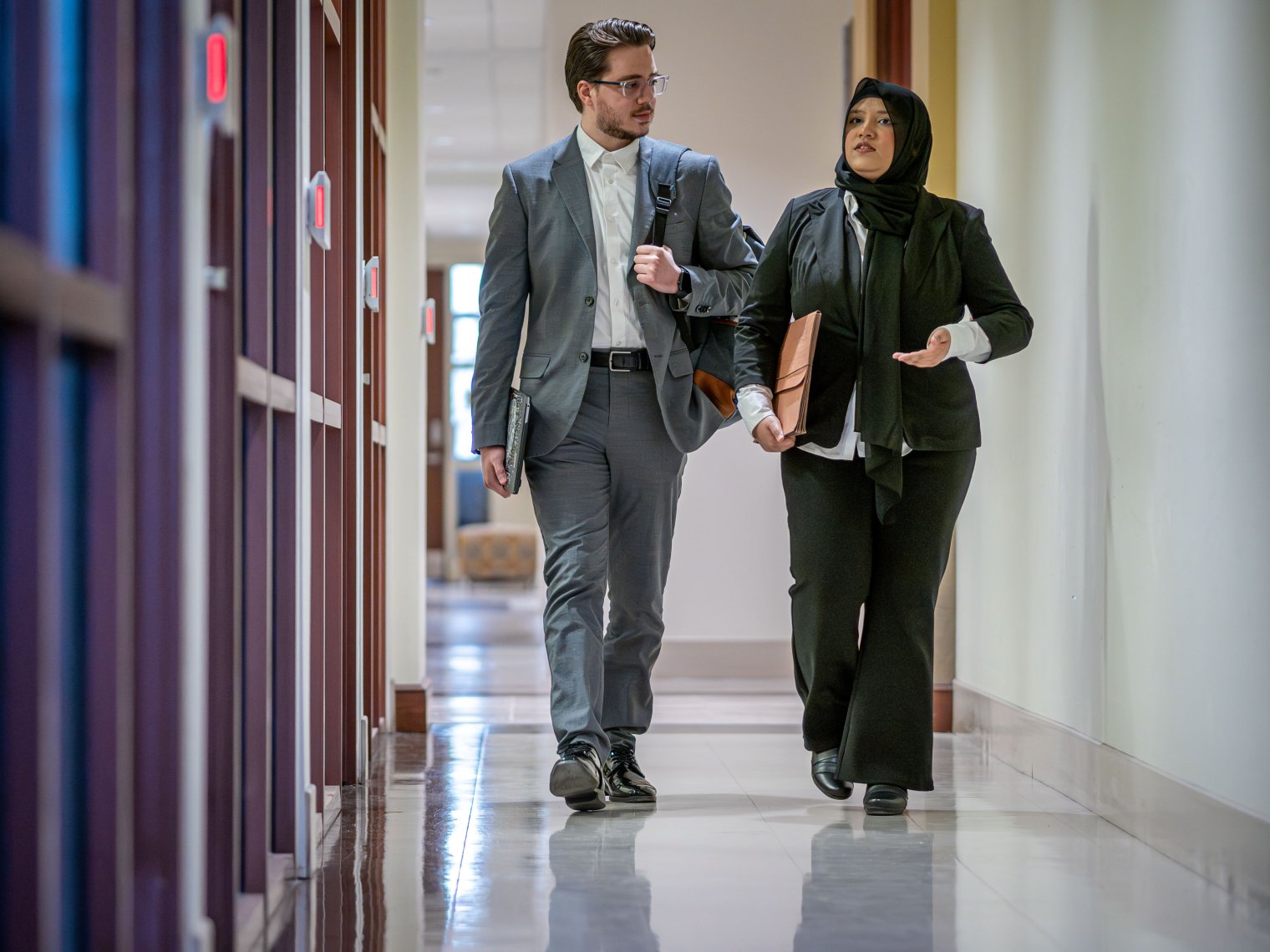 Two students walking down hallway