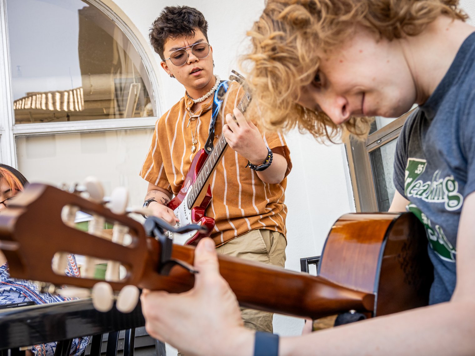 two students playing guitar