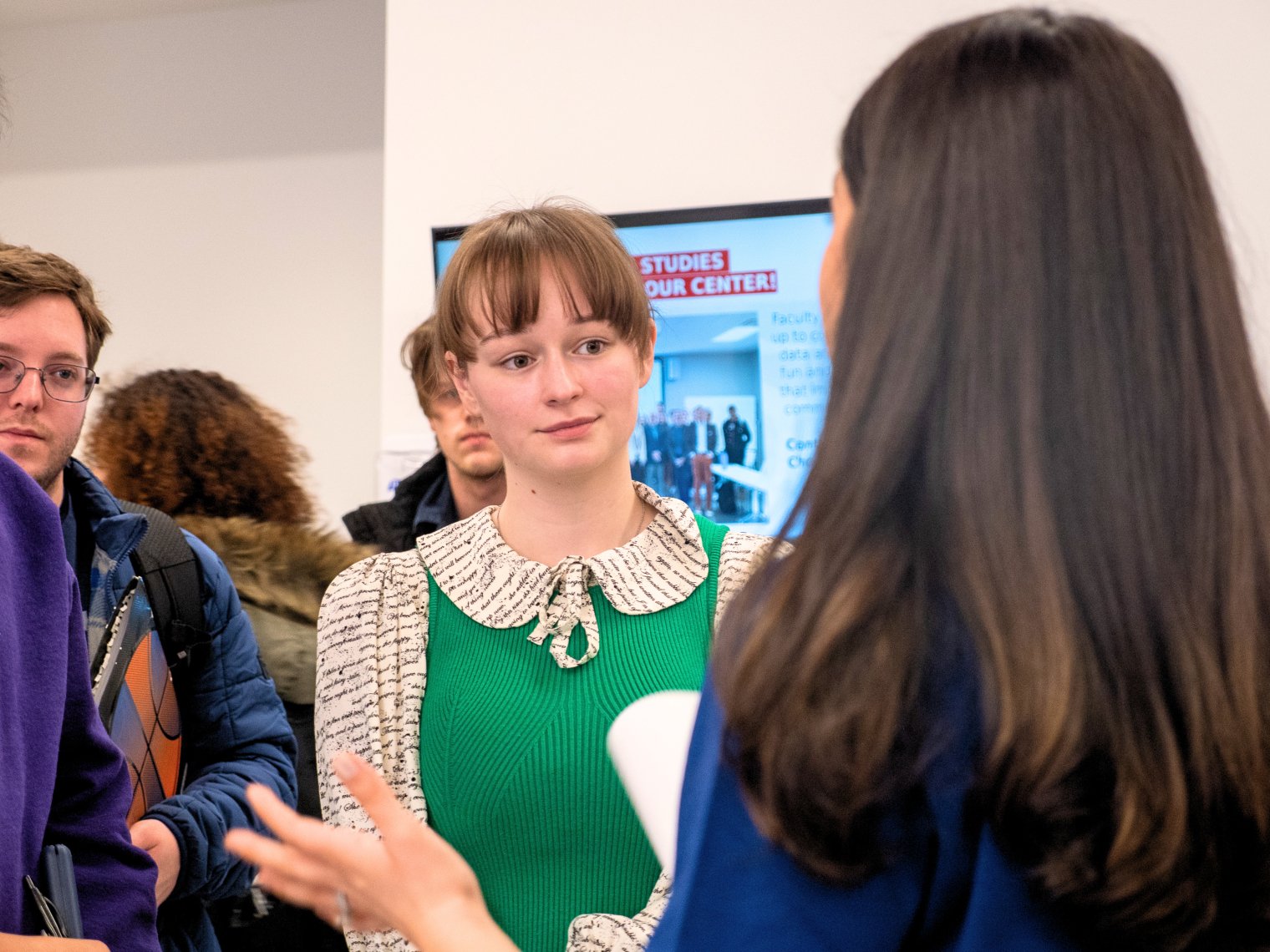 Students speaking to recruiter at a career fair event.