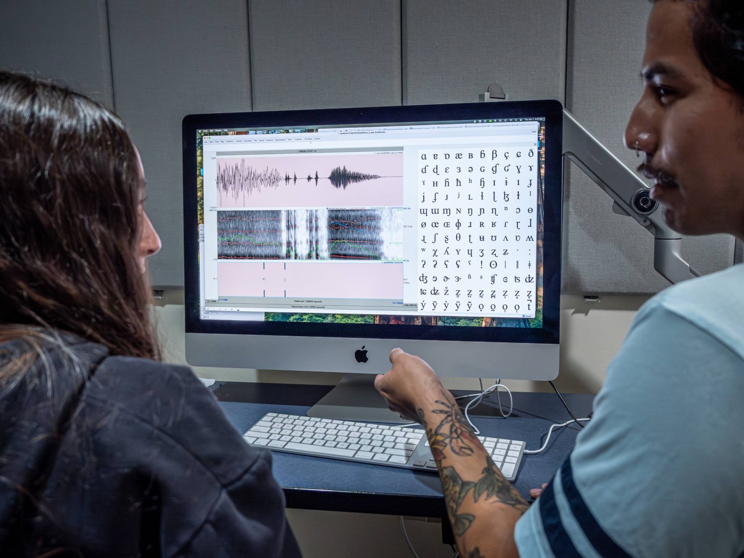 Two students in a classroom looking at a computer monitor