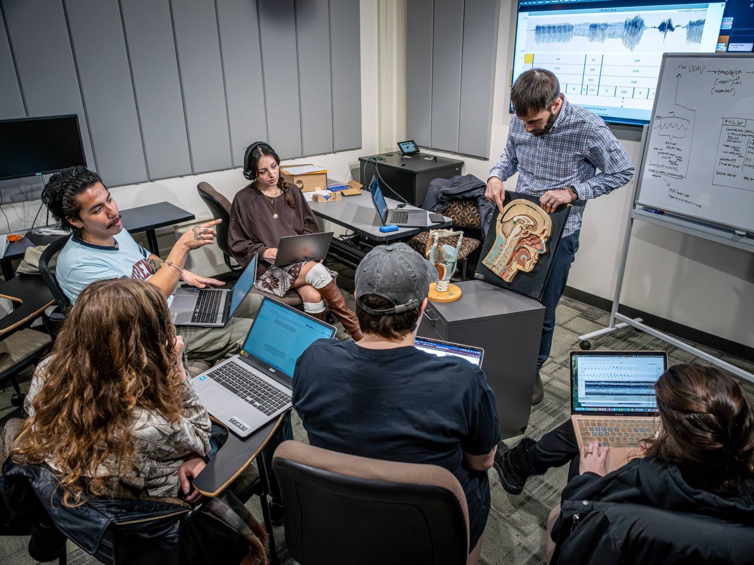 Professor leading a classroom demonstration while students watch