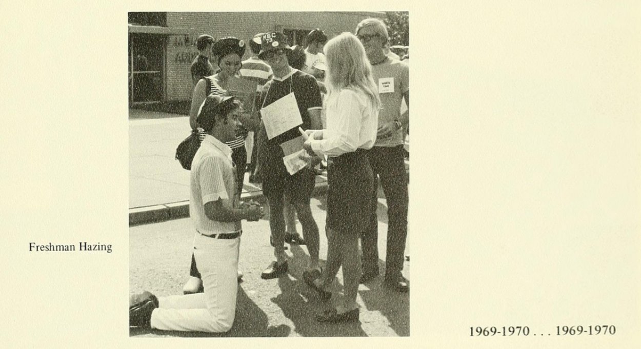 photo of student kneeling in front of other wearing dink hats