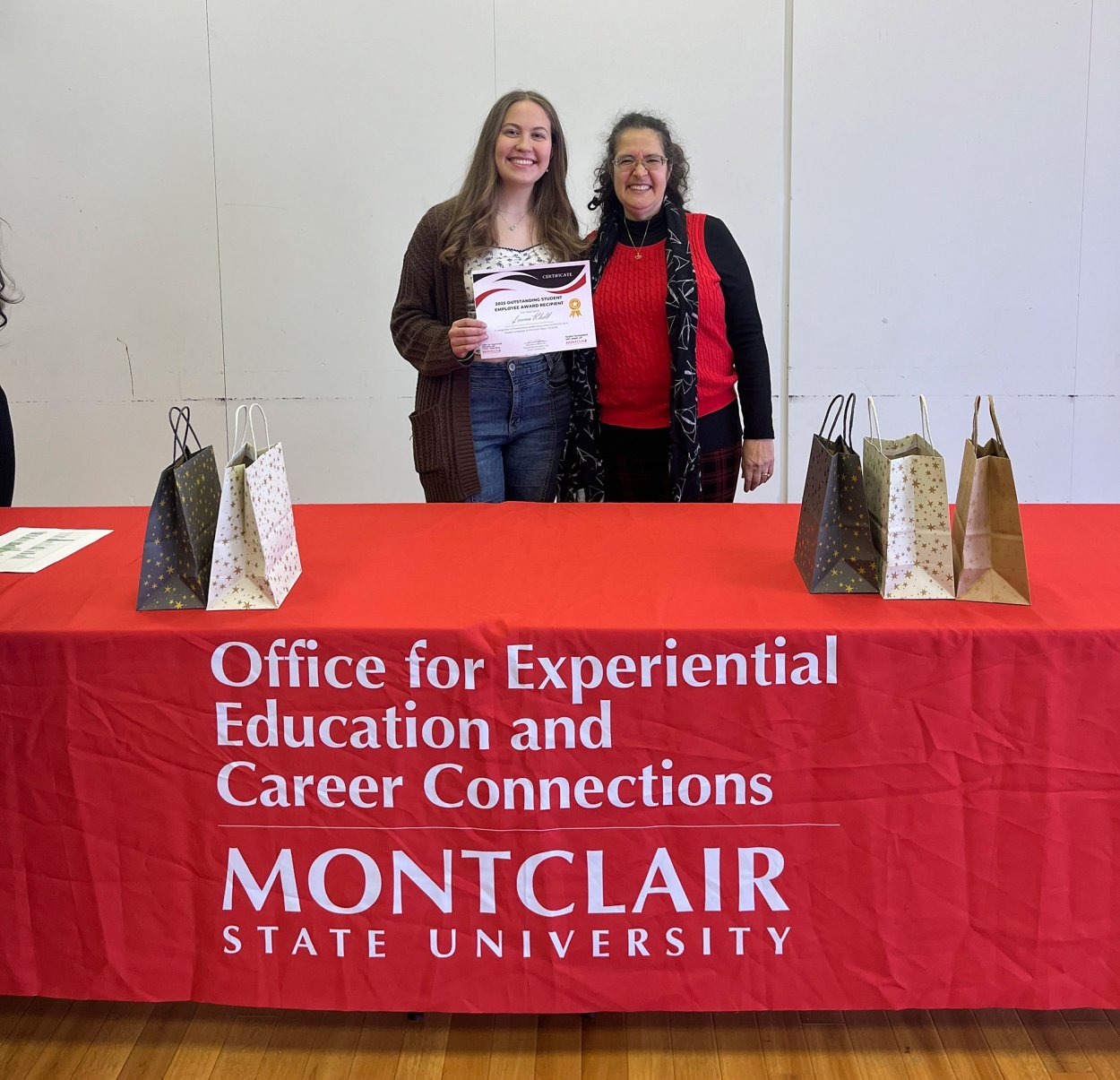 Lauren Khalil and Lisa Pendola standing behind table with gift bags