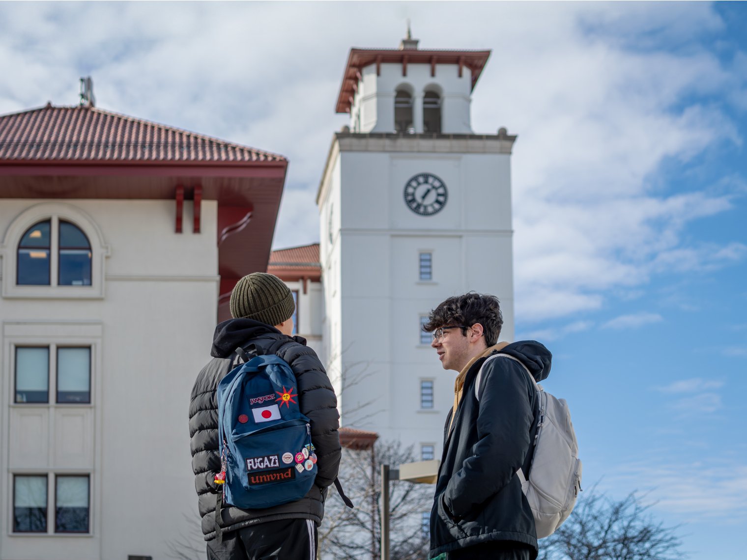 two students chatting outside of university hall. 