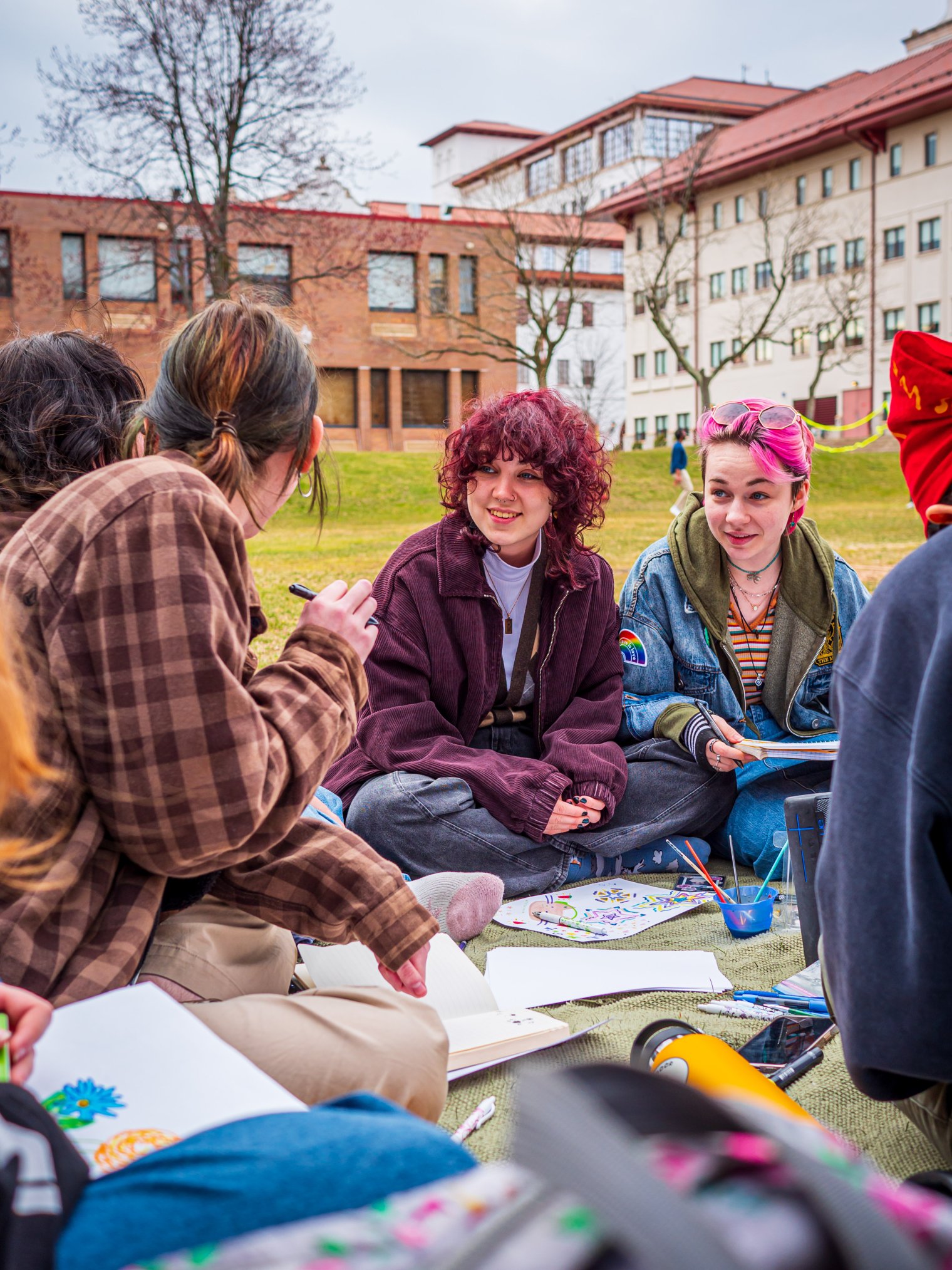 Students sitting in a semi circle working on a project outside