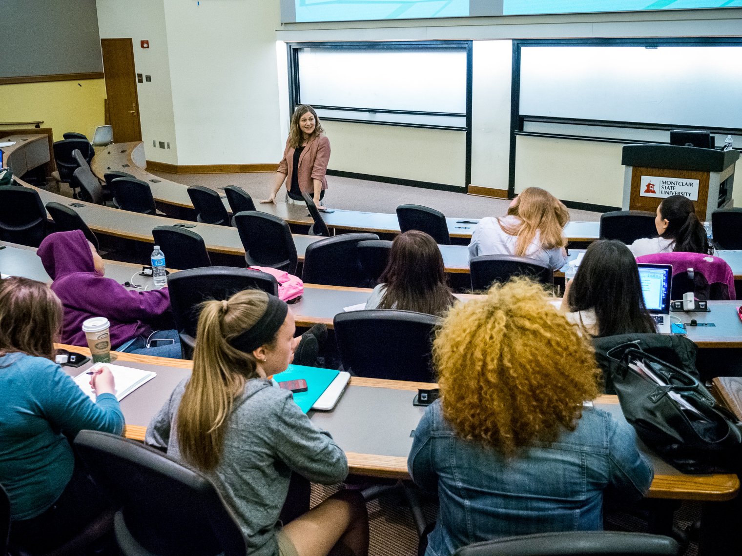 Students in a lecture hall with the professor at the front