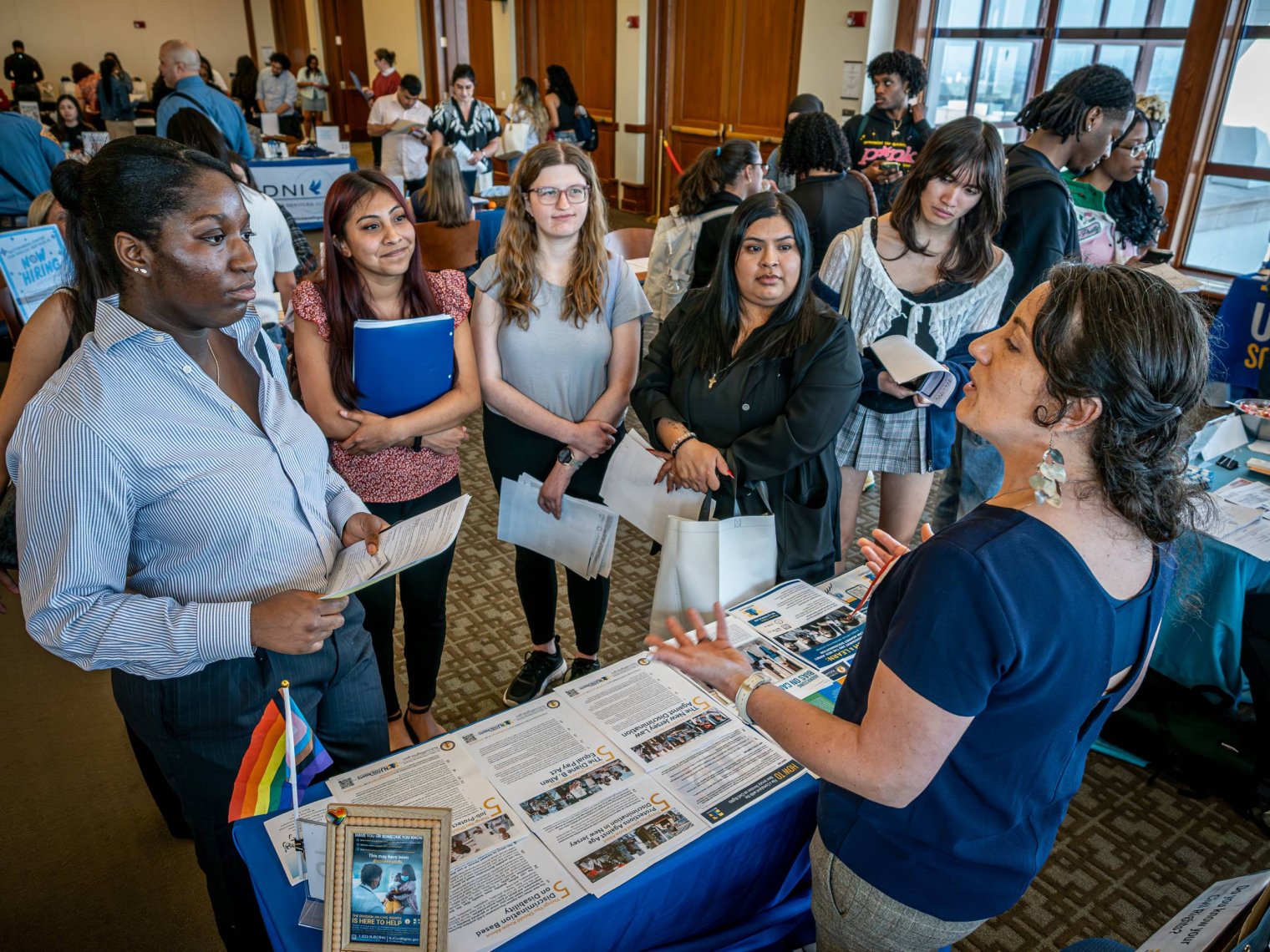 A recruiter speaks to a group of college students at a career fair