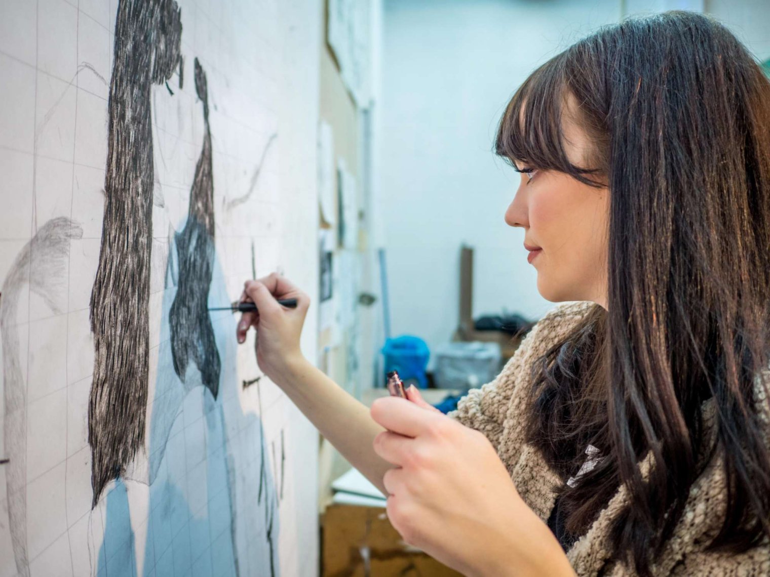Student drawing a figure at an easel